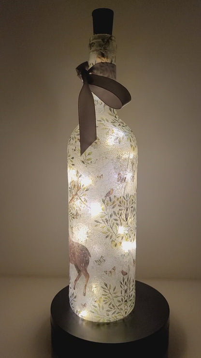 Rotating lit up wine bottle with Stag and leaf detail. Grey bow finish