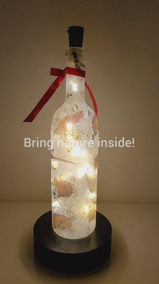 Rotating example of a Lit up wine bottle with wild animal detail. Red Bow