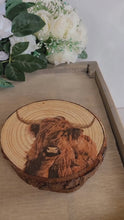 Load and play video in Gallery viewer, four wood slices with decoupage highland cows on. the coasters have bark around the edge
